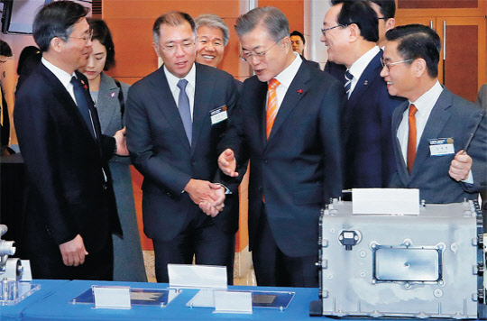 문재인 대통령이 17일 오전 울산시청 대회의실에서 열린 '수소 경제와 미래 에너지, 울산에서 시작됩니다' 행사에 참석하기에 앞서 수소 활용 전시장을 둘러보고 있다. 문 대통령이 수소 활용 모빌리티 (수소차, 드론 등) 부스를 둘러보다 수소차 넥쏘에 대해 정의선 현대차 부회장에게 질문하고 있다.  연합뉴스